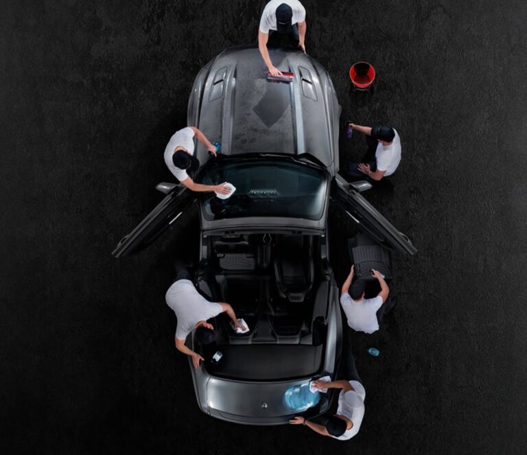 Detailing crew working on a car from above
